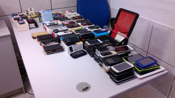 Quatro pessoas são presas acusadas de receptação de celulares e um menor apreendido.